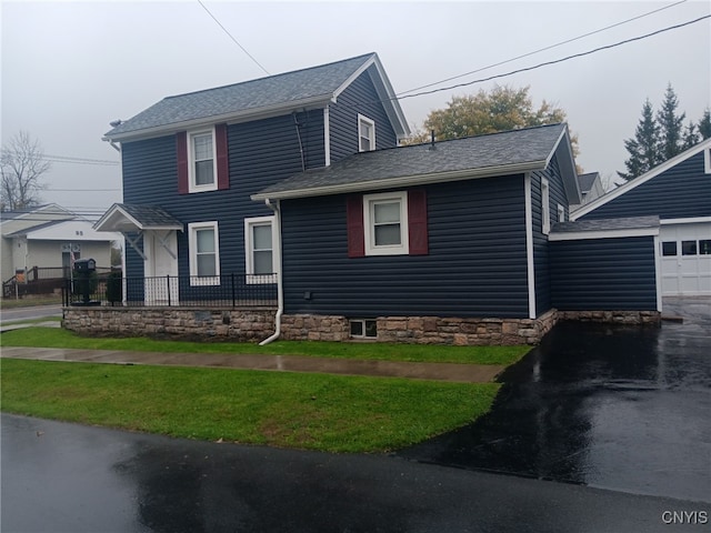 view of front facade with a garage, a shingled roof, and asphalt driveway