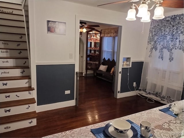 interior space featuring baseboards, dark wood finished floors, and arched walkways