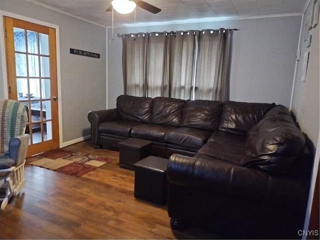 living area with a ceiling fan, crown molding, baseboards, and wood finished floors