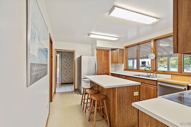 kitchen featuring a breakfast bar area, sink, appliances with stainless steel finishes, and a center island