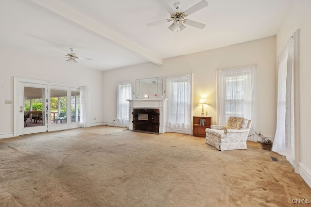 unfurnished living room with beam ceiling, light colored carpet, a fireplace, and ceiling fan