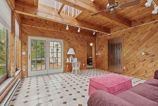 unfurnished living room with beam ceiling, a healthy amount of sunlight, and wooden walls