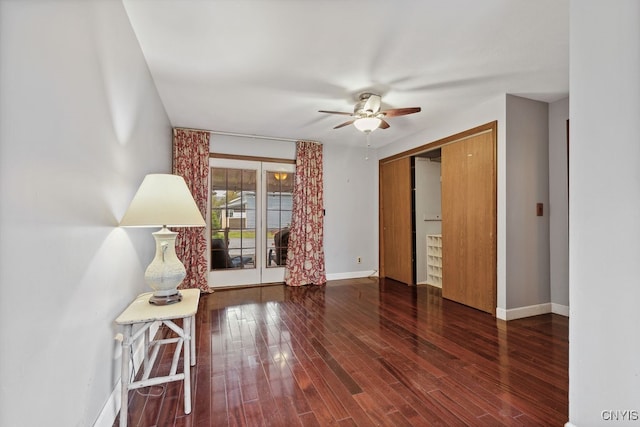 empty room with dark hardwood / wood-style floors and ceiling fan