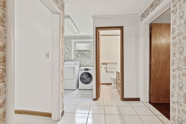 clothes washing area with independent washer and dryer and light tile patterned floors