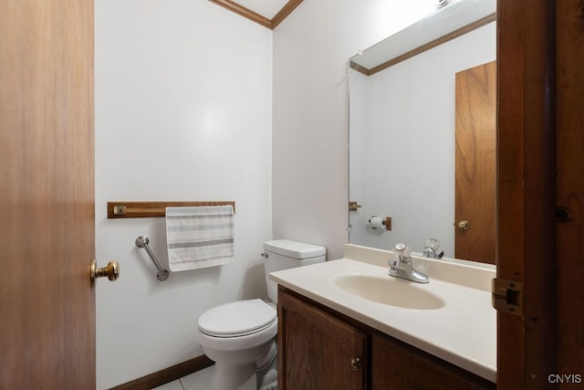 bathroom with toilet, ornamental molding, vanity, and tile patterned floors