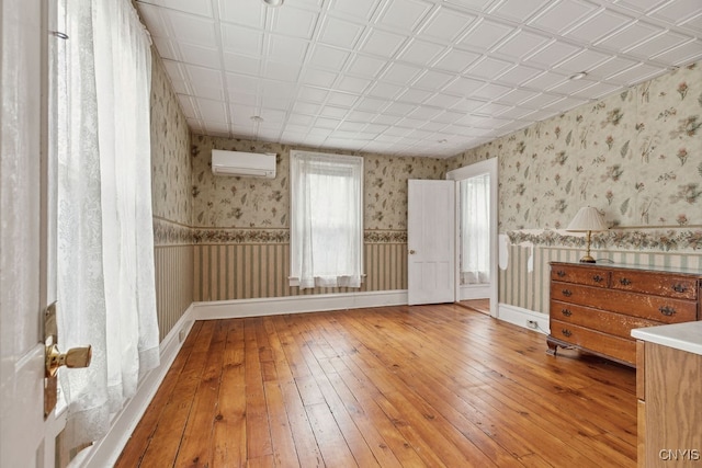 spare room with a wall mounted air conditioner and wood-type flooring