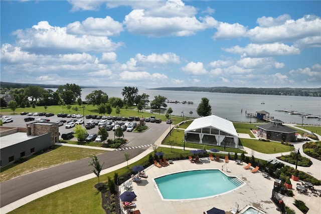 view of pool with a water view and a patio