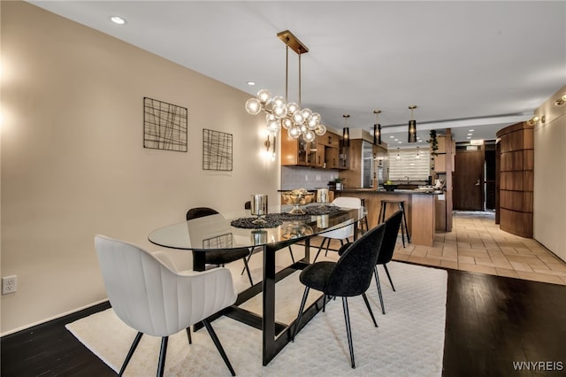 dining space with a notable chandelier and light wood-type flooring