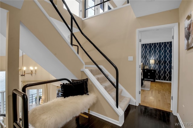 stairway with an inviting chandelier and hardwood / wood-style floors