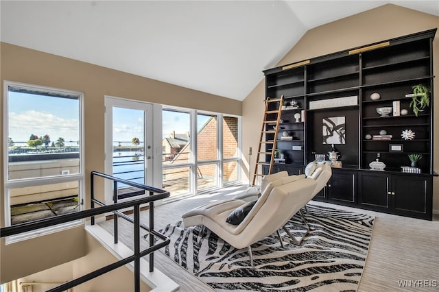 carpeted home office featuring french doors, a healthy amount of sunlight, and vaulted ceiling