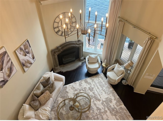 living room with ornamental molding, a chandelier, and wood-type flooring