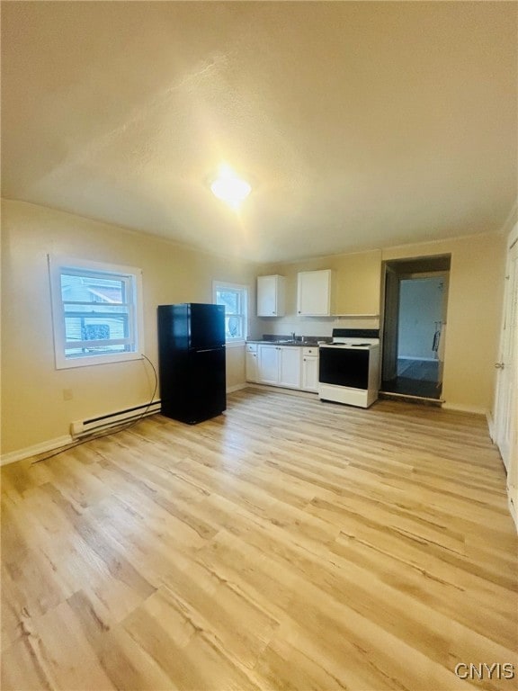 kitchen featuring white cabinets, a baseboard heating unit, black fridge, white electric range oven, and light hardwood / wood-style floors