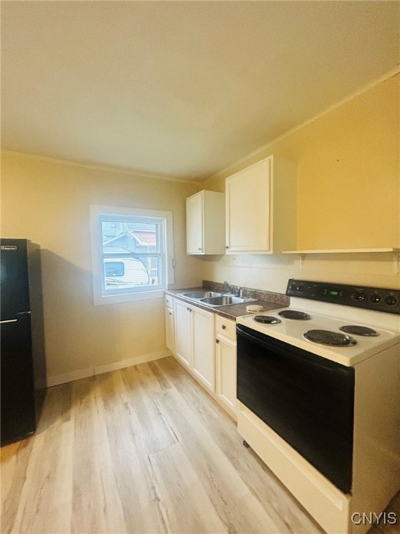 kitchen featuring black refrigerator, sink, white cabinetry, light hardwood / wood-style floors, and electric stove