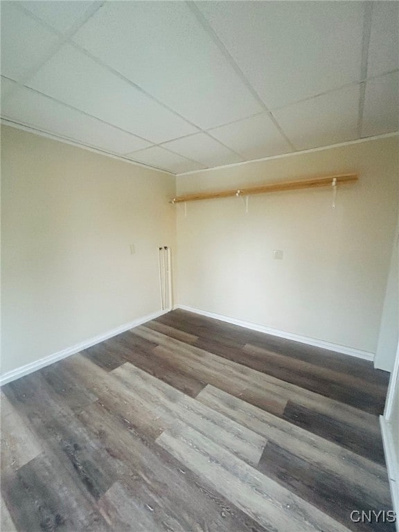 spare room with dark wood-type flooring and a paneled ceiling