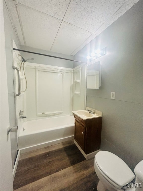 full bathroom featuring toilet, bathing tub / shower combination, hardwood / wood-style floors, vanity, and a paneled ceiling