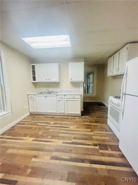 kitchen with white cabinets, light hardwood / wood-style flooring, and white appliances