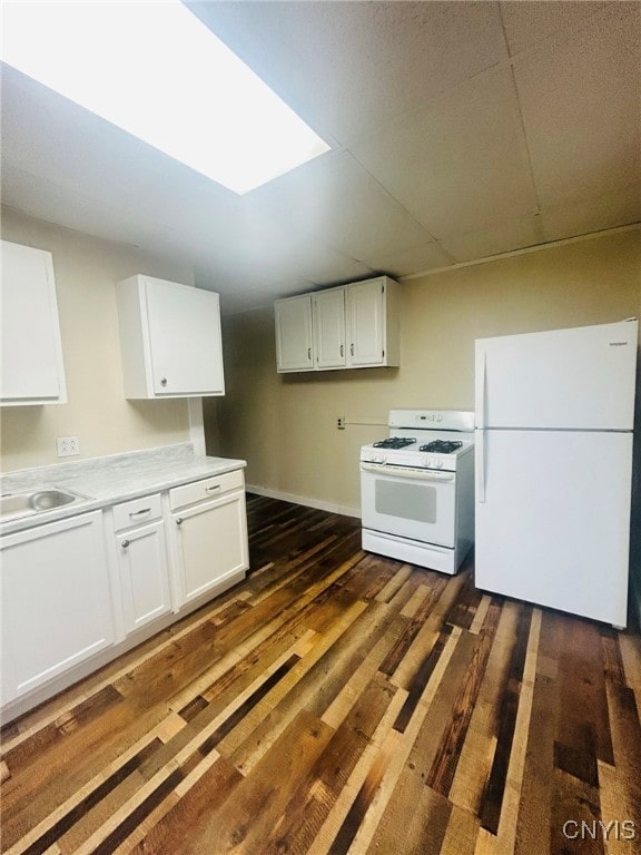 kitchen with white cabinets, dark hardwood / wood-style floors, and white appliances