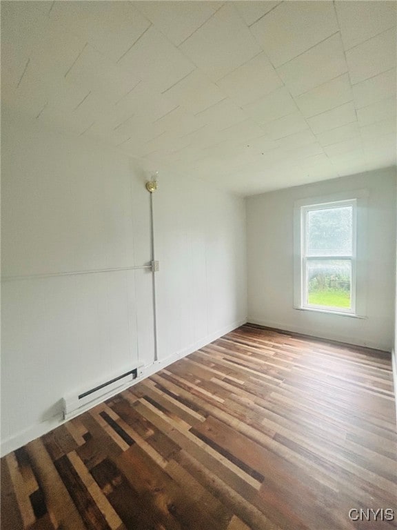 empty room with a baseboard heating unit and hardwood / wood-style flooring