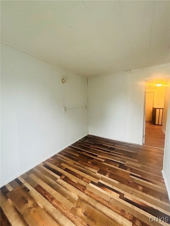 empty room with dark hardwood / wood-style flooring