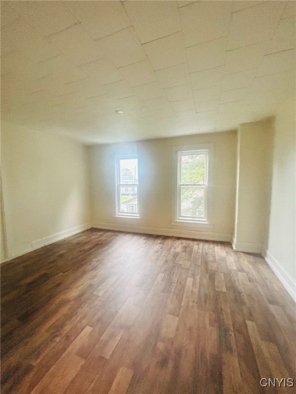 unfurnished room with dark wood-type flooring