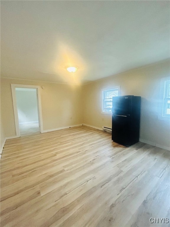 interior space featuring baseboard heating and light wood-type flooring