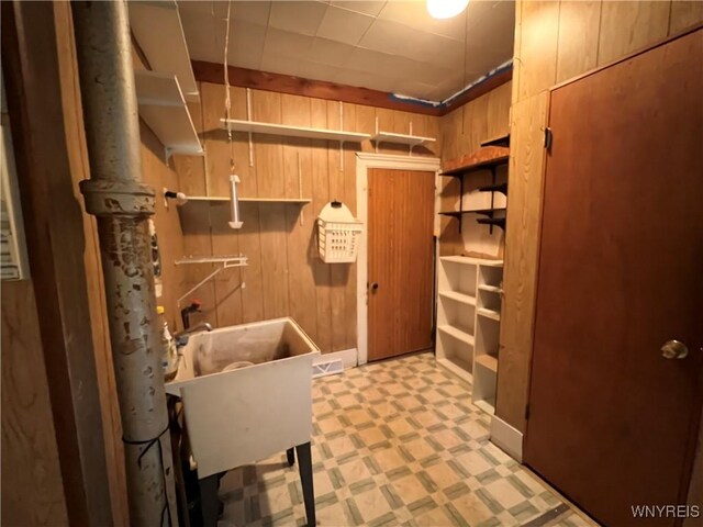 bathroom featuring wooden walls and sink