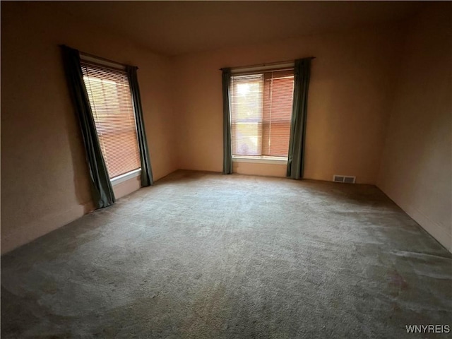 carpeted spare room featuring visible vents