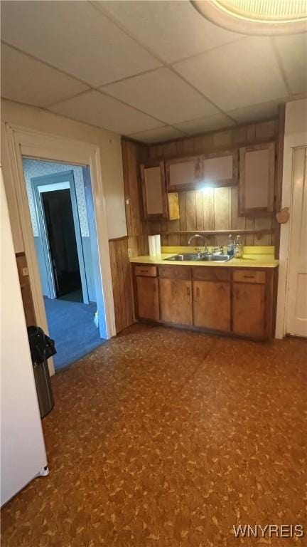 kitchen featuring brown cabinetry, light countertops, and a sink