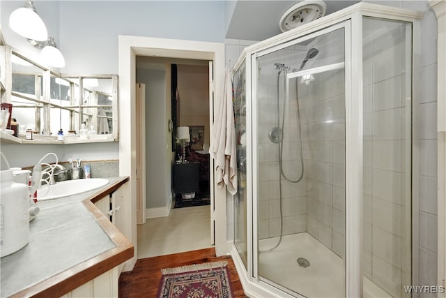 bathroom featuring wood-type flooring, vanity, and a shower with shower door