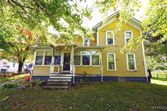 view of front facade with a sunroom and a front lawn