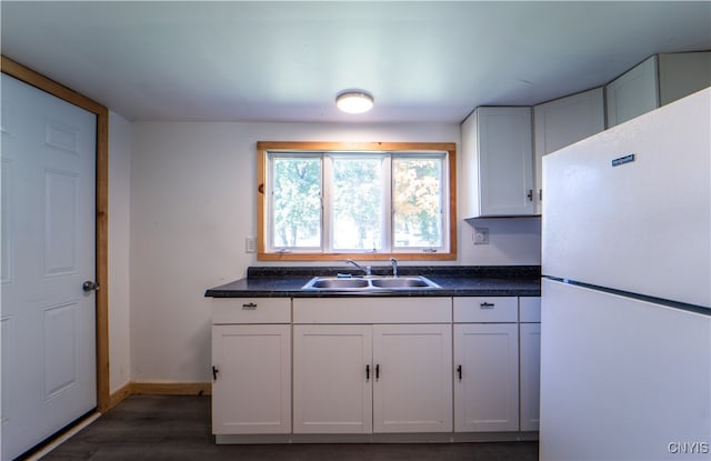 kitchen featuring white fridge, dark hardwood / wood-style flooring, sink, and white cabinets