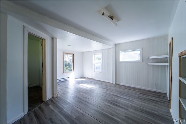 unfurnished living room with wood walls, a baseboard radiator, and dark hardwood / wood-style flooring