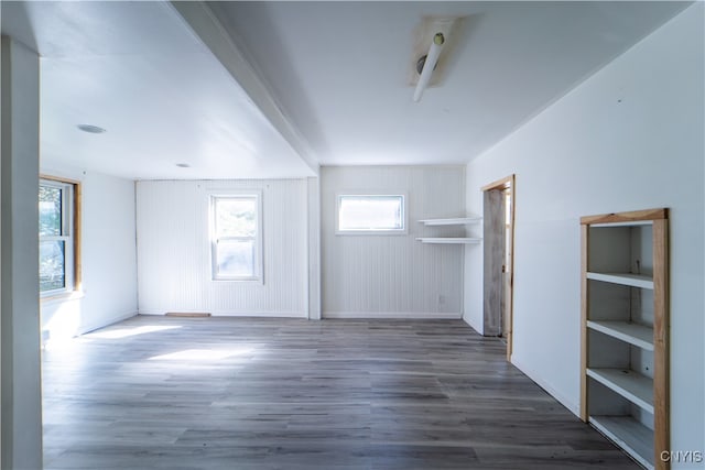 spare room featuring dark wood-type flooring and wooden walls