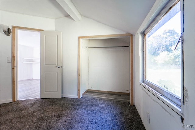 unfurnished bedroom featuring lofted ceiling with beams, multiple windows, a closet, and carpet floors