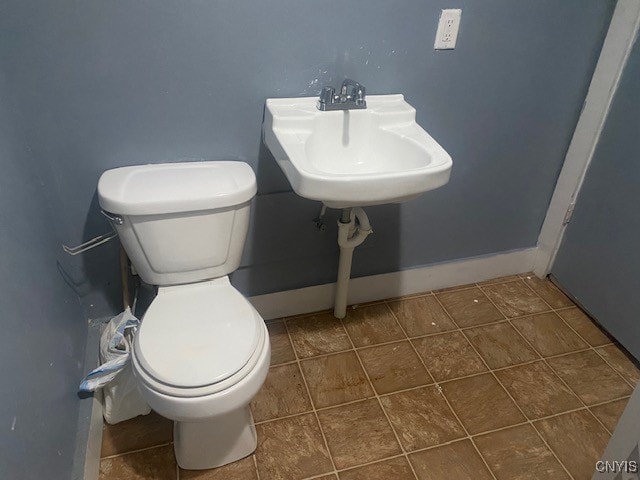 bathroom featuring toilet, sink, and tile patterned floors