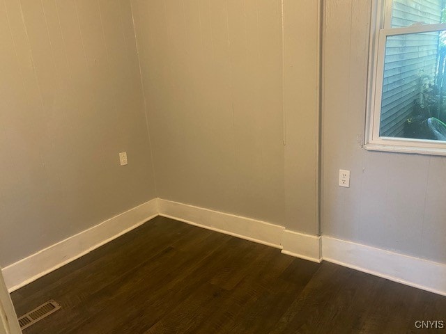 unfurnished room with dark wood-type flooring