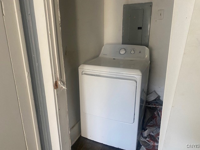 clothes washing area with washer / clothes dryer, electric panel, and dark hardwood / wood-style flooring