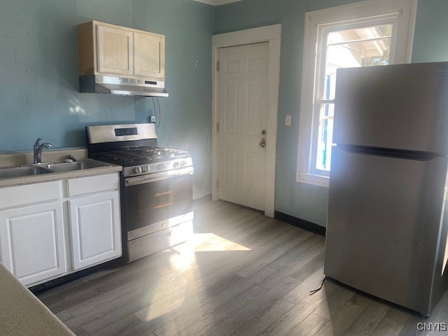 kitchen with a healthy amount of sunlight, appliances with stainless steel finishes, and dark hardwood / wood-style flooring