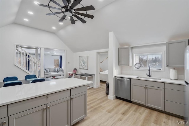 kitchen featuring gray cabinetry, dishwasher, lofted ceiling, ceiling fan, and light wood-type flooring