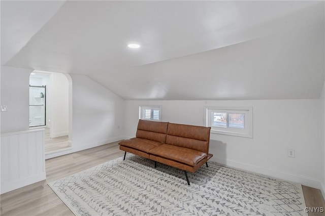 living area with light wood-type flooring and vaulted ceiling