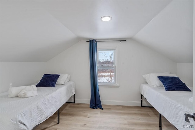 bedroom with light hardwood / wood-style floors and lofted ceiling