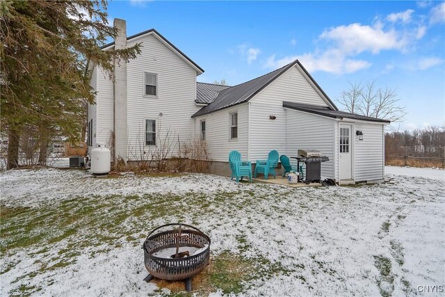 snow covered rear of property with cooling unit