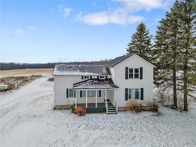 snow covered property with covered porch