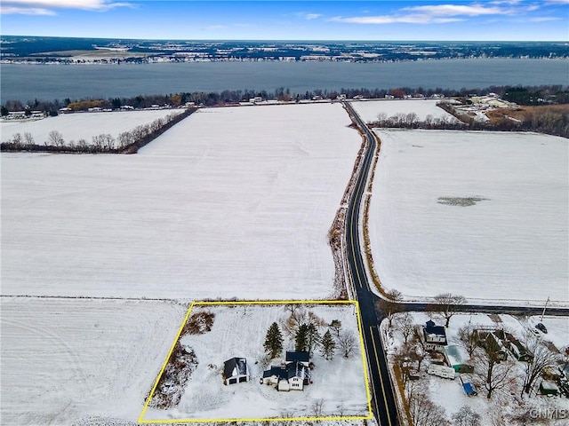 snowy aerial view featuring a water view