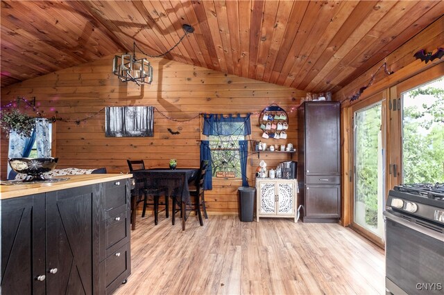 kitchen with gas range, wood ceiling, wooden walls, and light wood-type flooring