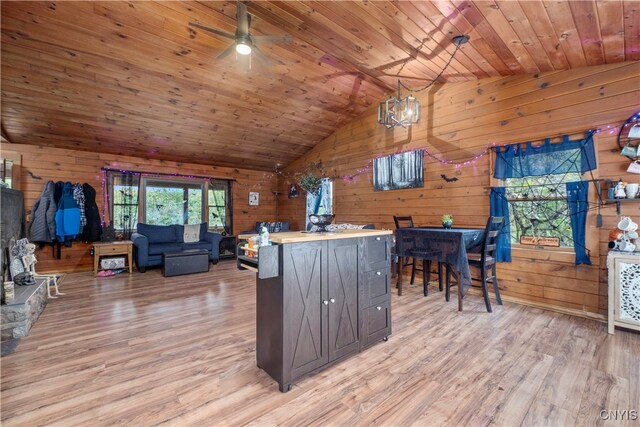 kitchen featuring wooden walls, wooden ceiling, vaulted ceiling, light wood-type flooring, and ceiling fan with notable chandelier