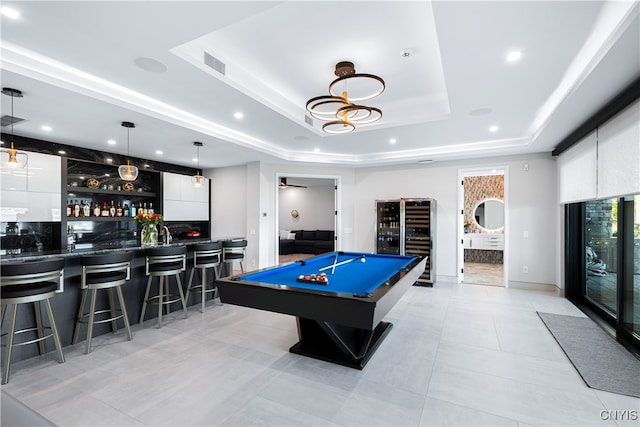 recreation room featuring a raised ceiling, pool table, and indoor bar