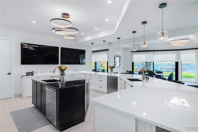 kitchen featuring a large island, white cabinetry, sink, and hanging light fixtures