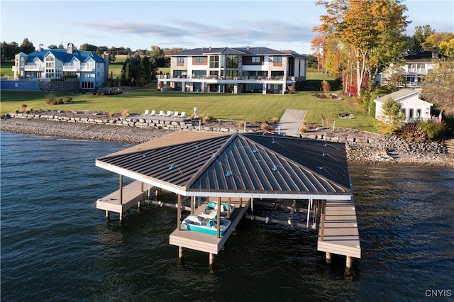 view of dock with a yard and a water view