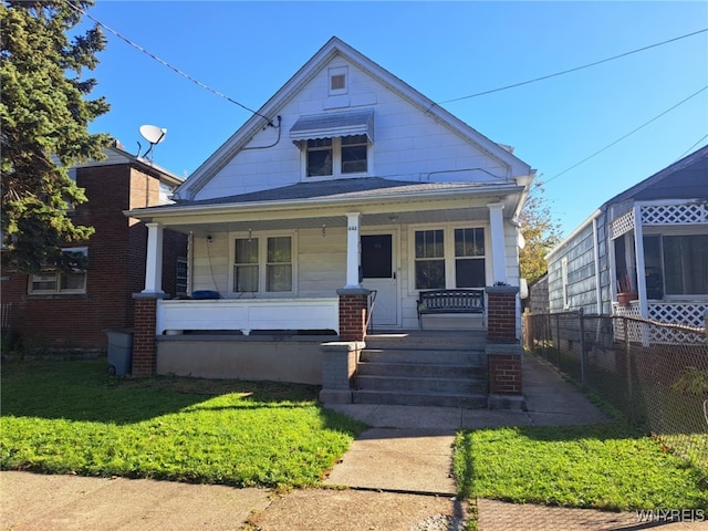 bungalow featuring a front yard and covered porch